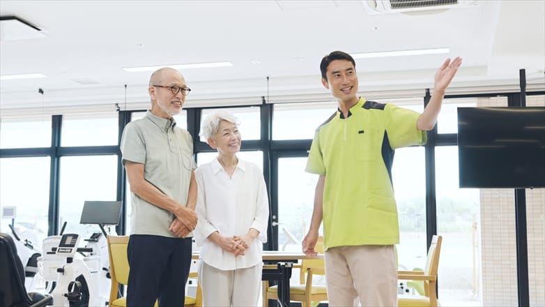 施設の案内係が見学に来たご夫婦に館内を説明している