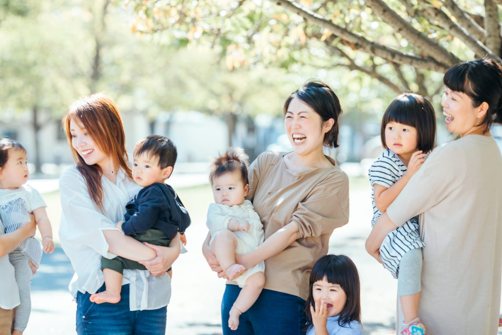 子どもを抱いて笑い合う母親たち