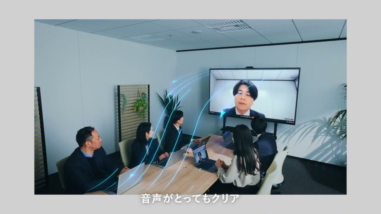 会議室の大型画面に遠隔地の相手を映し、WEB会議をしている様子