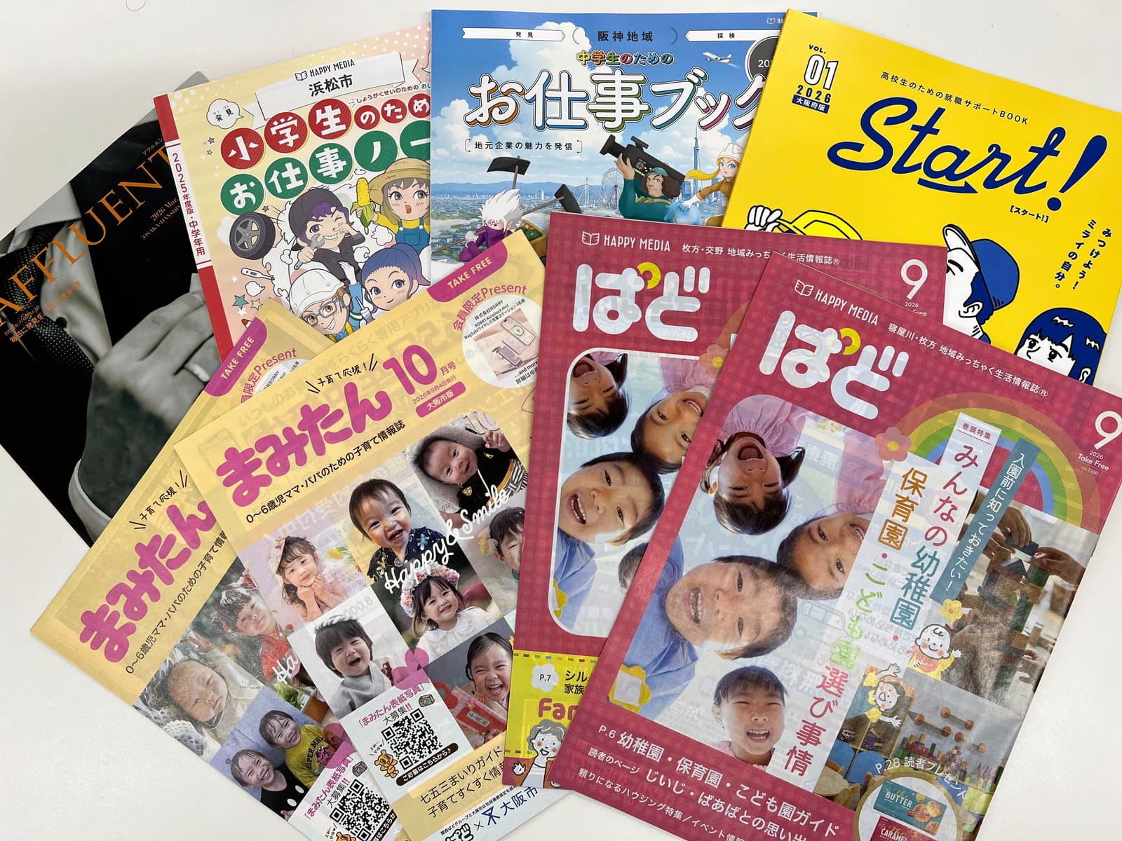 フリーマガジン「まみたん」「ぱど」、「アフルエント」、「お仕事ノート」「お仕事ブック」「Start!」の誌面を重ねて並べた写真