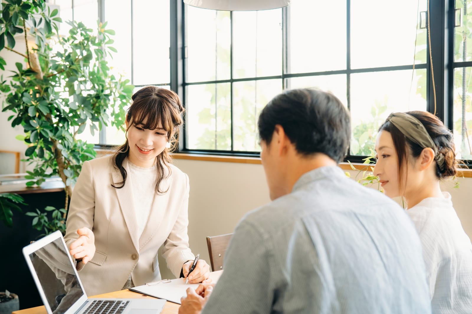 ノートパソコンと資料を前に、担当者が向かいに座ったお客様へ説明している様子