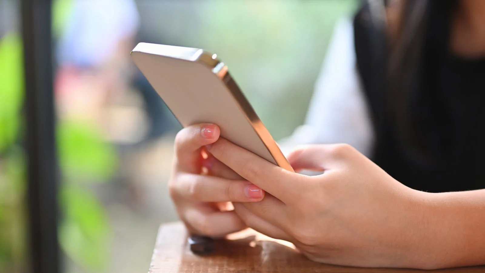スマートフォンを両手で持って操作している手元